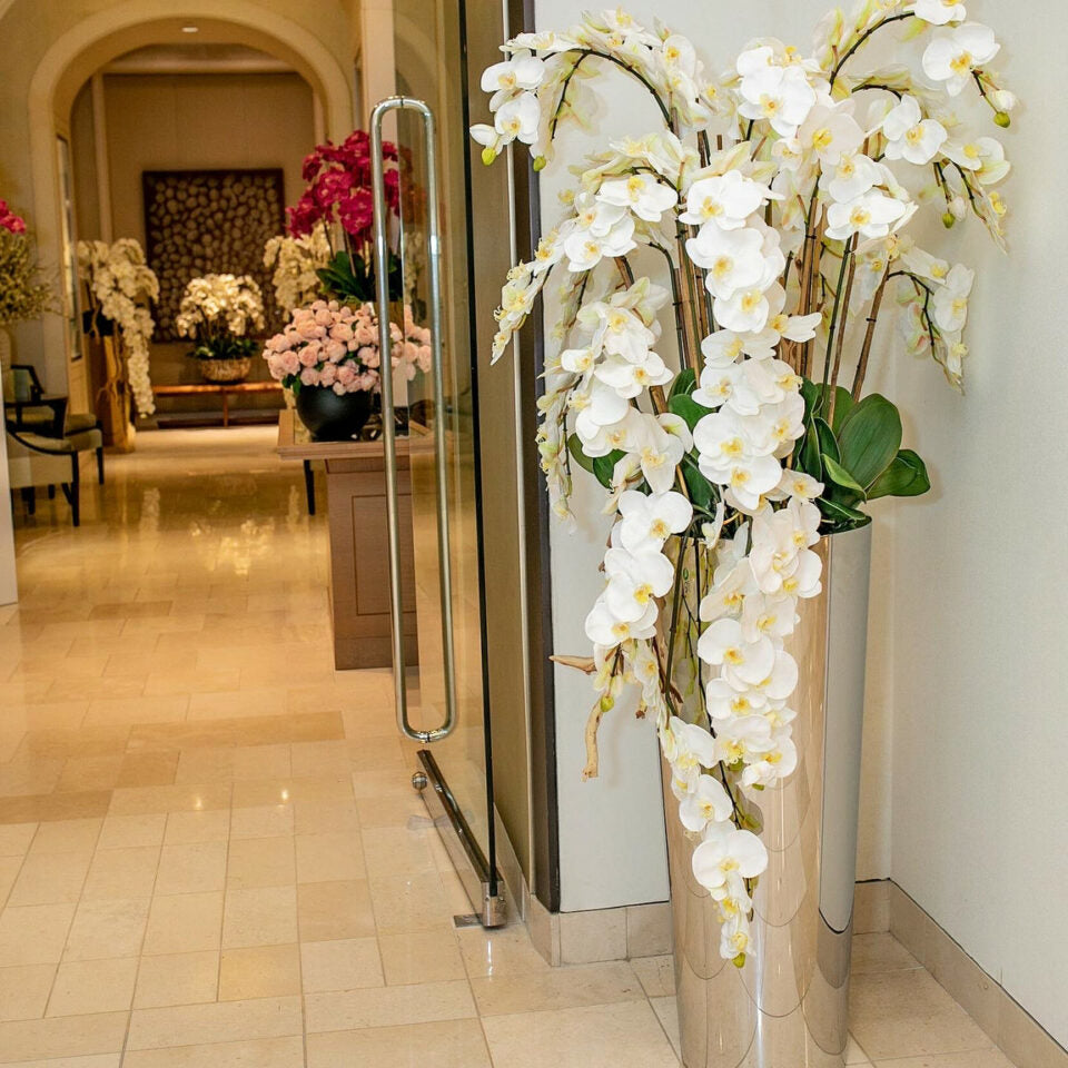 Kaskadierende Phalaenopsis-Orchideen auf poliertem Edelstahlkegel