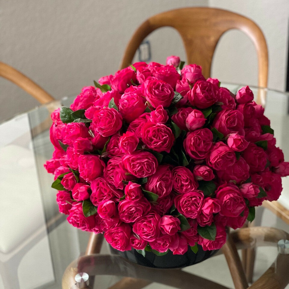 Dunkelrosafarbene englische Rosen in schwarzer Glasvase