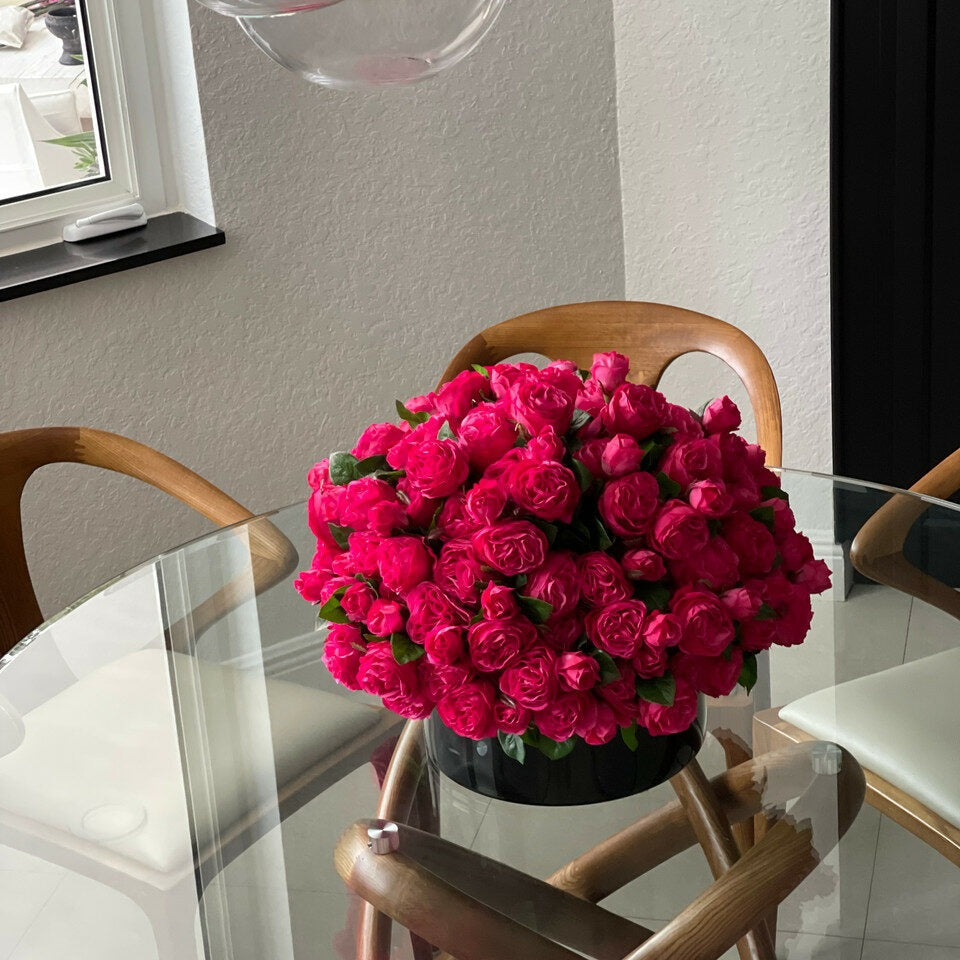 Dunkelrosafarbene englische Rosen in schwarzer Glasvase