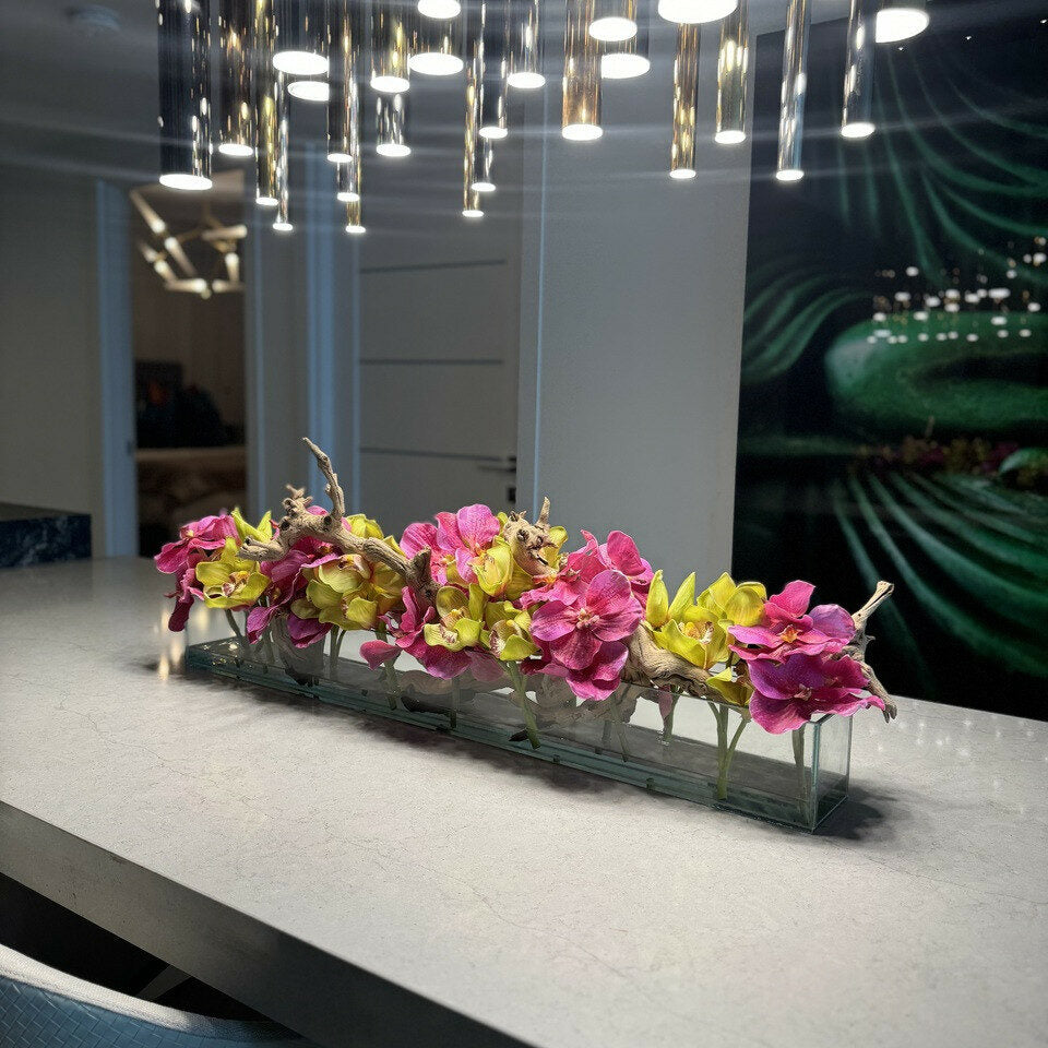 Moderne Haus-Glasvase mit pinkfarbenen Vanda-Orchideen und grünen Cymbidien