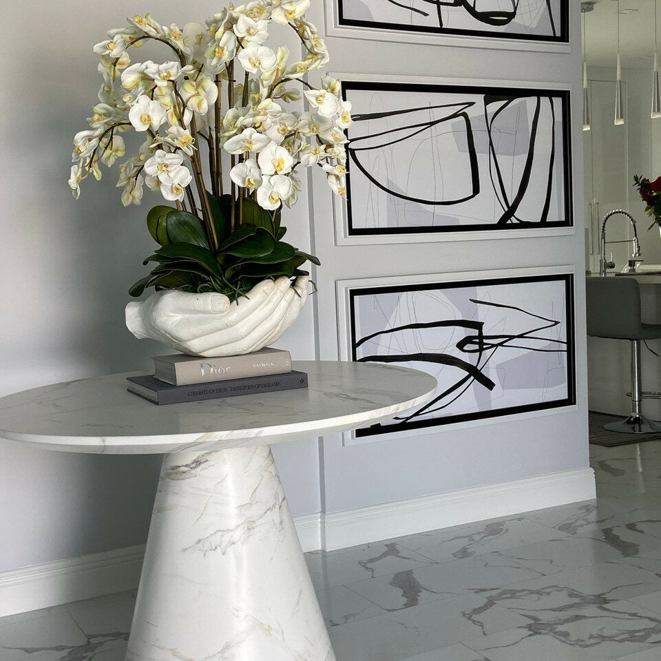 Weiße Phalaenopsis-Orchideen in Vase mit Skulptur „Offene Hände“