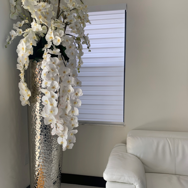 Kaskadierende Phalaenopsis-Orchideen in extrahoher gehämmerter Vase