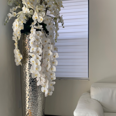 Kaskadierende Phalaenopsis-Orchideen in extrahoher gehämmerter Vase